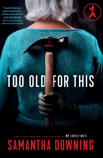 Back view of a silver-haired woman in a teal sweater holding a hammer behind her back.